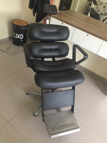 Cadeira de barbeiro com bancada e espelho.