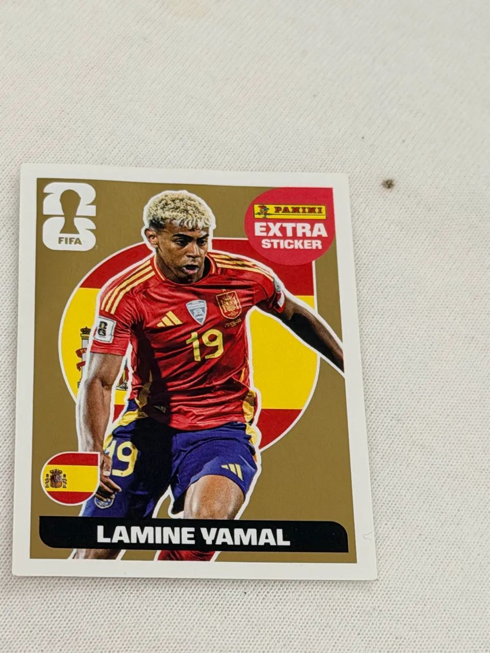 Figurinha de ouro do lamine tampa