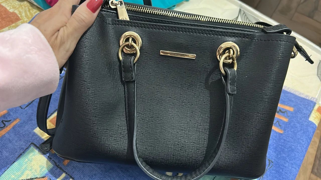Bolsa preta elegante com detalhes dourados