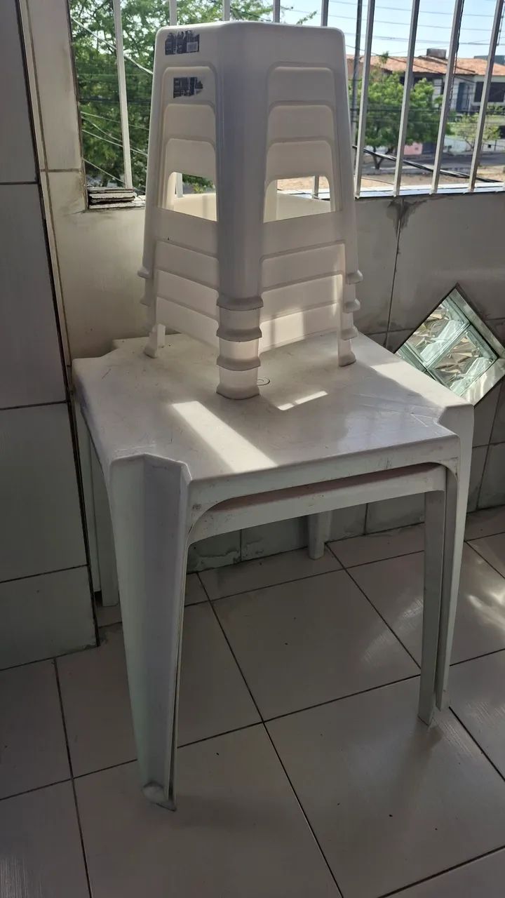 Mesas de plástico branca e bancos