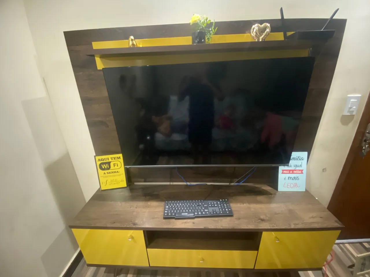 Painel de TV com rack amarelo e marrom