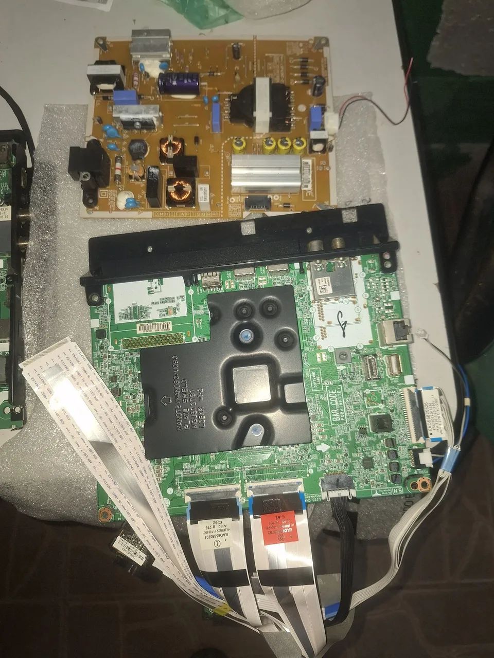 Uma placa da TV LG com placa de da fonte cabos flet incluindo sensor remoto; e outra placa