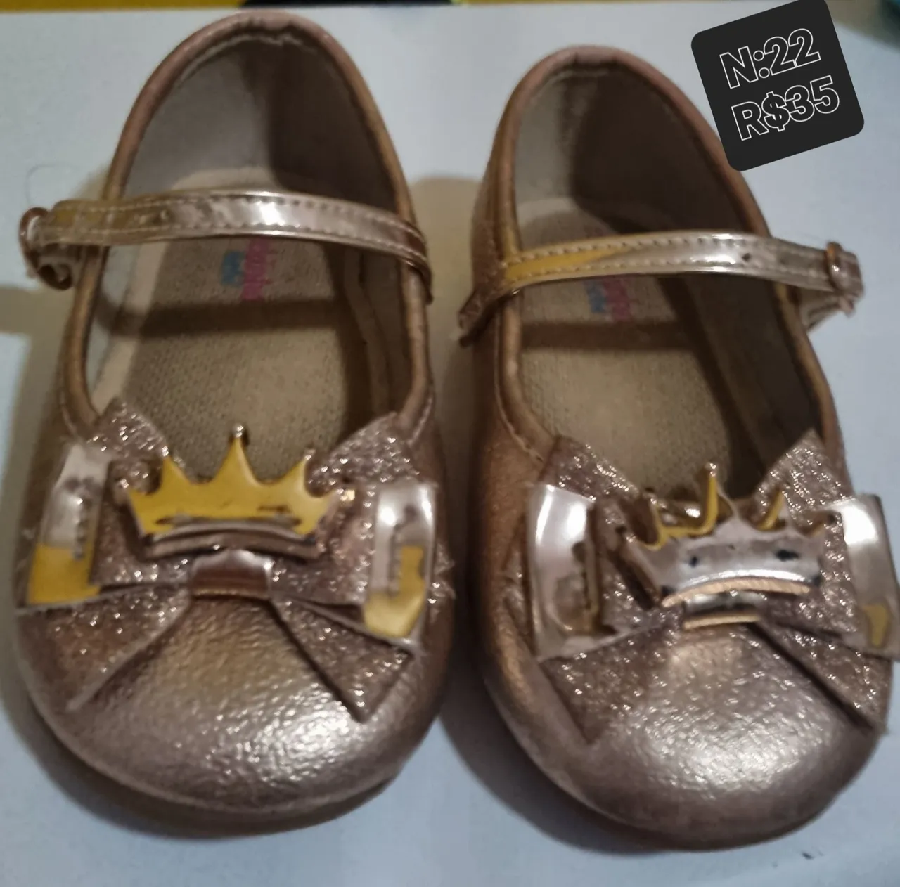Sapatilha infantil dourada com coroa e laço
