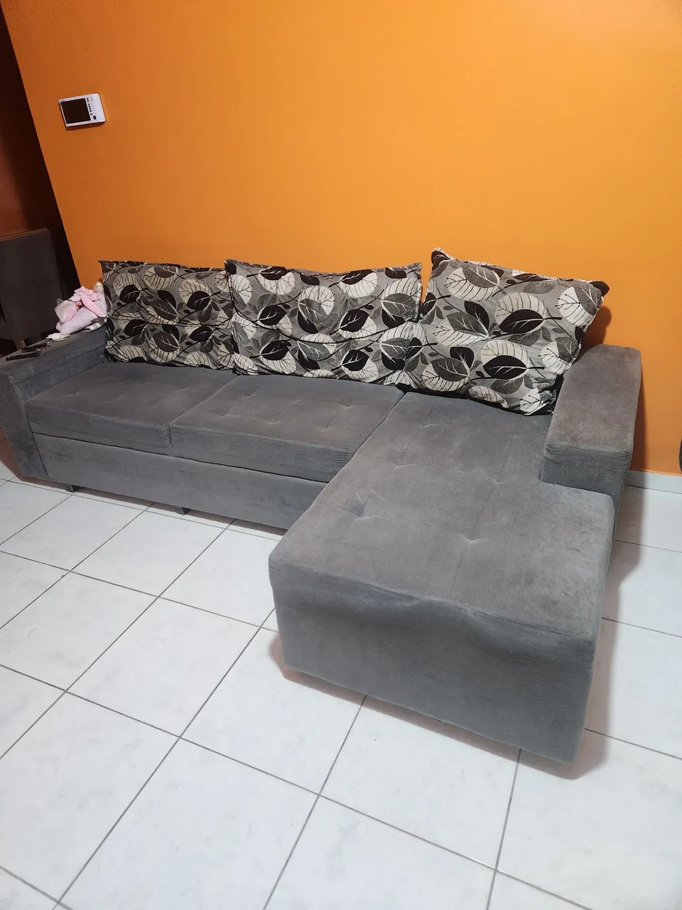 Sofá de canto cinza com almofadas decorativas