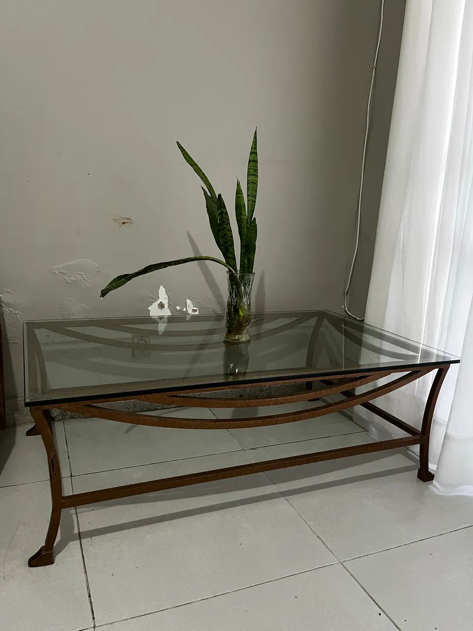 Mesa de centro com tampo de vidro e estrutura metálica