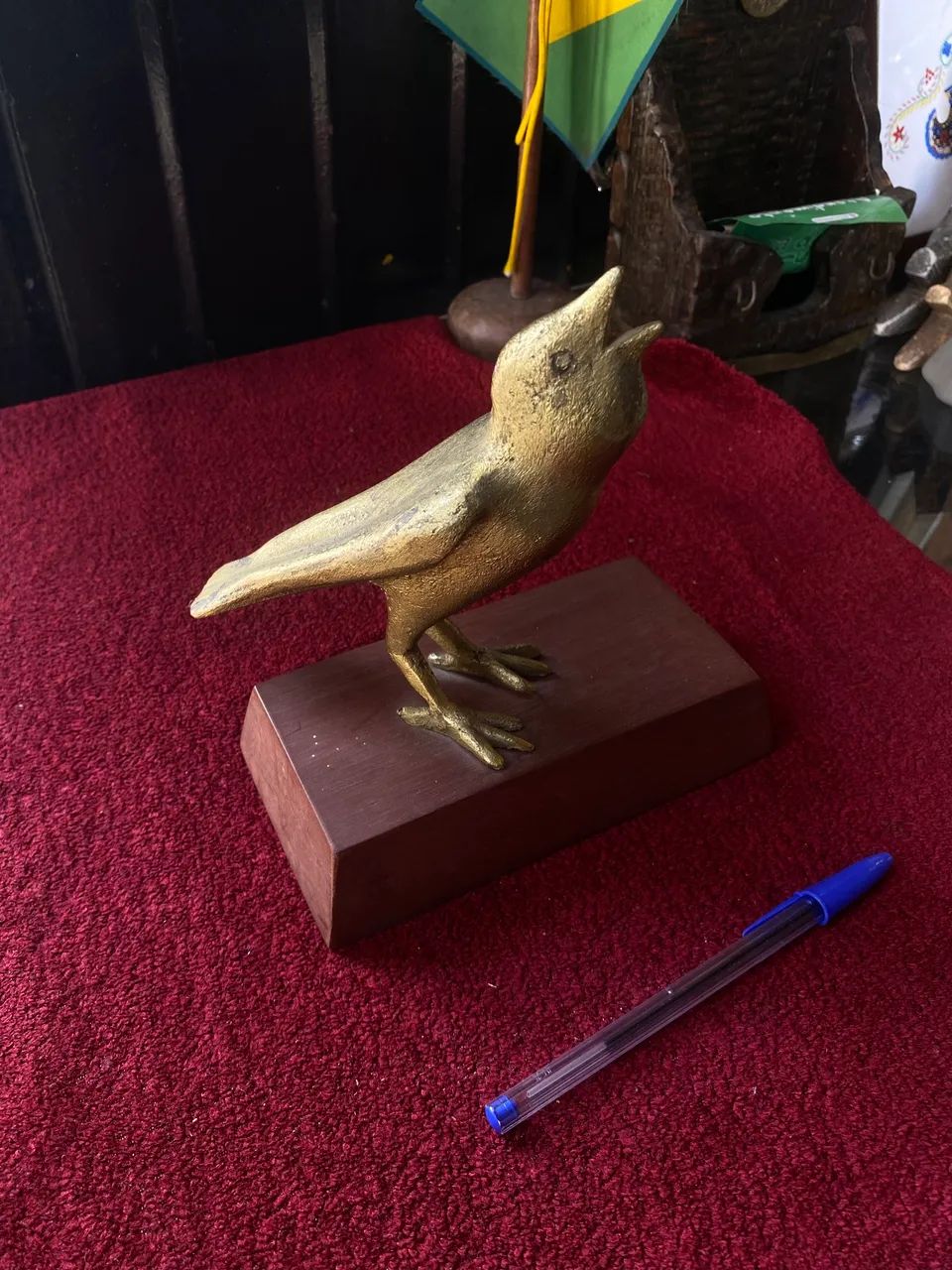 Escultura de pássaro em metal com base em madeira 
