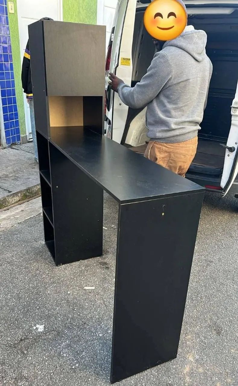 Bancada multiuso preta com armário e prateleira.