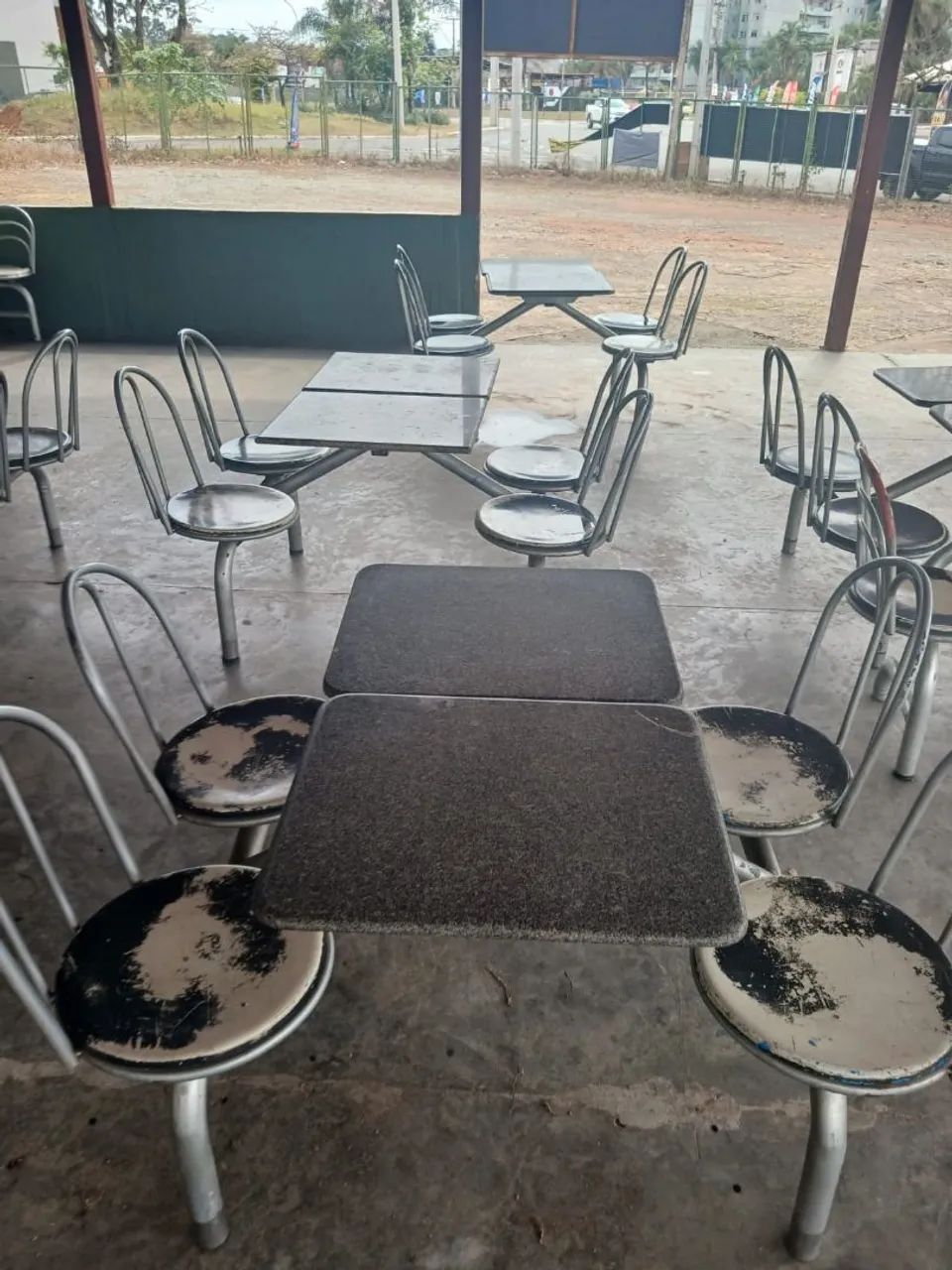 Mesas com jogo de cadeira acoplada.