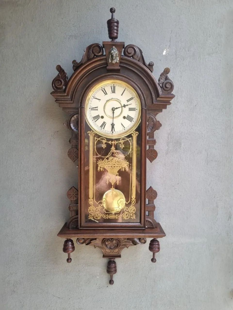 Relógio antigo marca Gilbert com cabeça de Jenny Lindy e pêndulo decorativo. 
