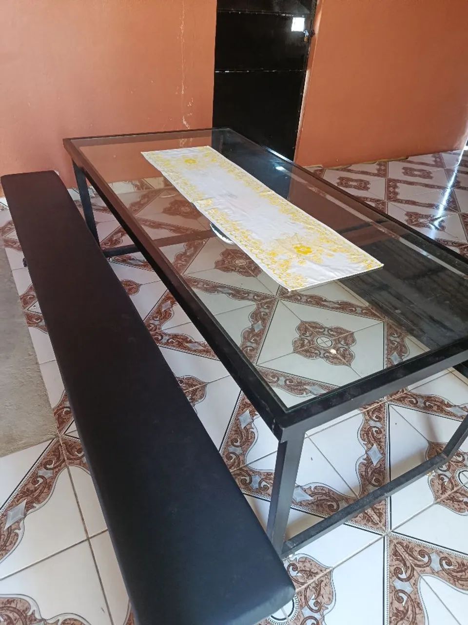 Mesa de vidro com a base de ferro e bancos