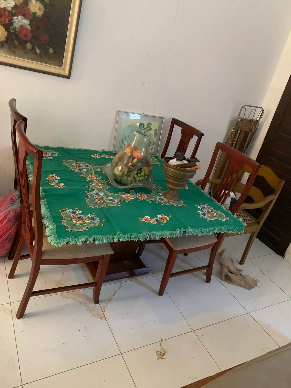 Mesa com tampo de vidro boleado com quatro cadeiras.