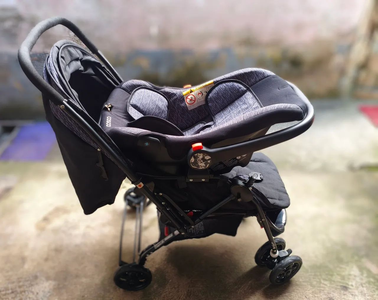 Carrinho com bebê conforto Cosco.