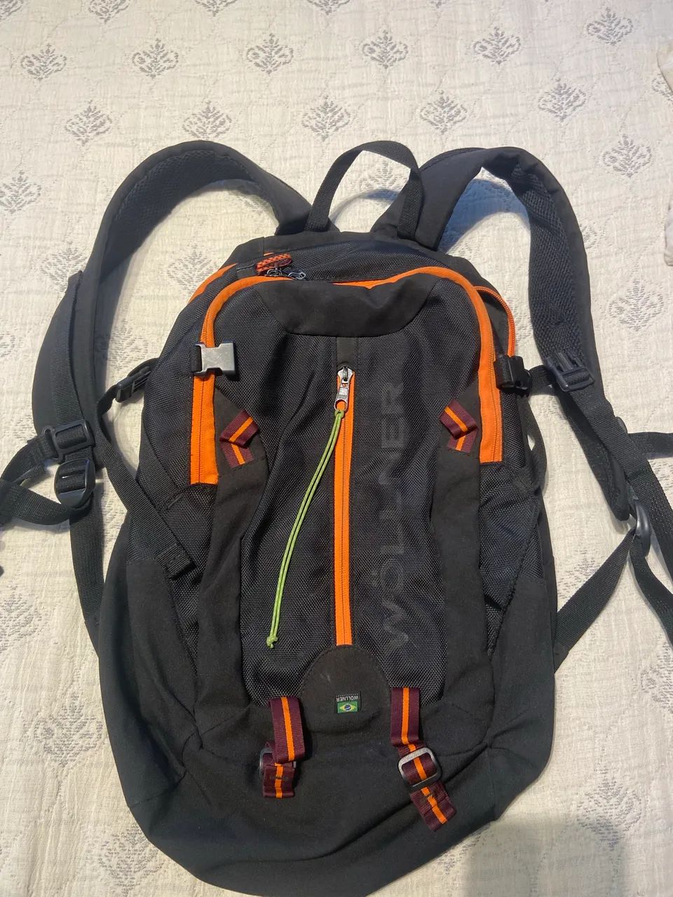 Mochila da Wöllner preta com detalhes laranja, modelo Ipanema
