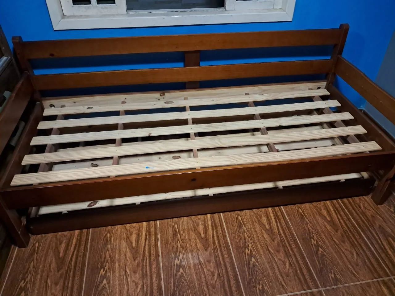 Single wooden bed with an auxiliary bed.