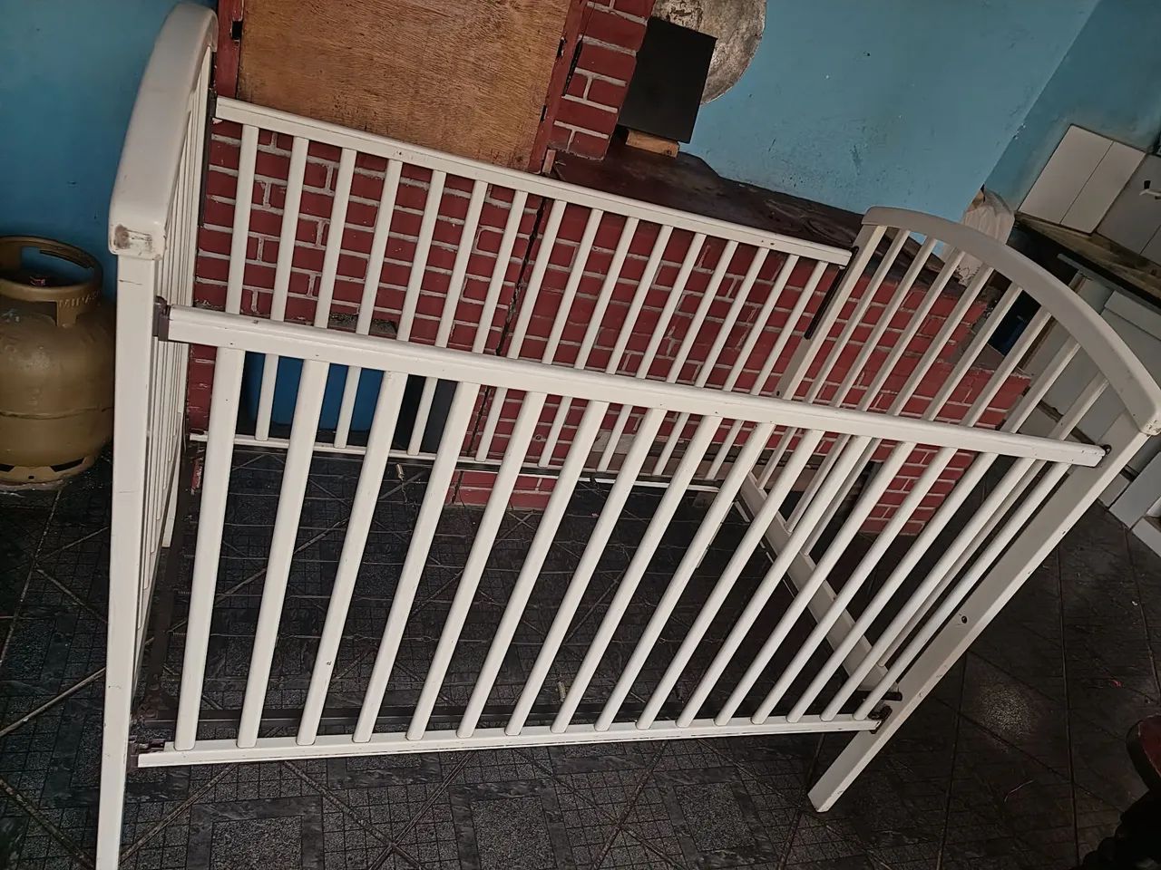 Berço branco com grade de molas.