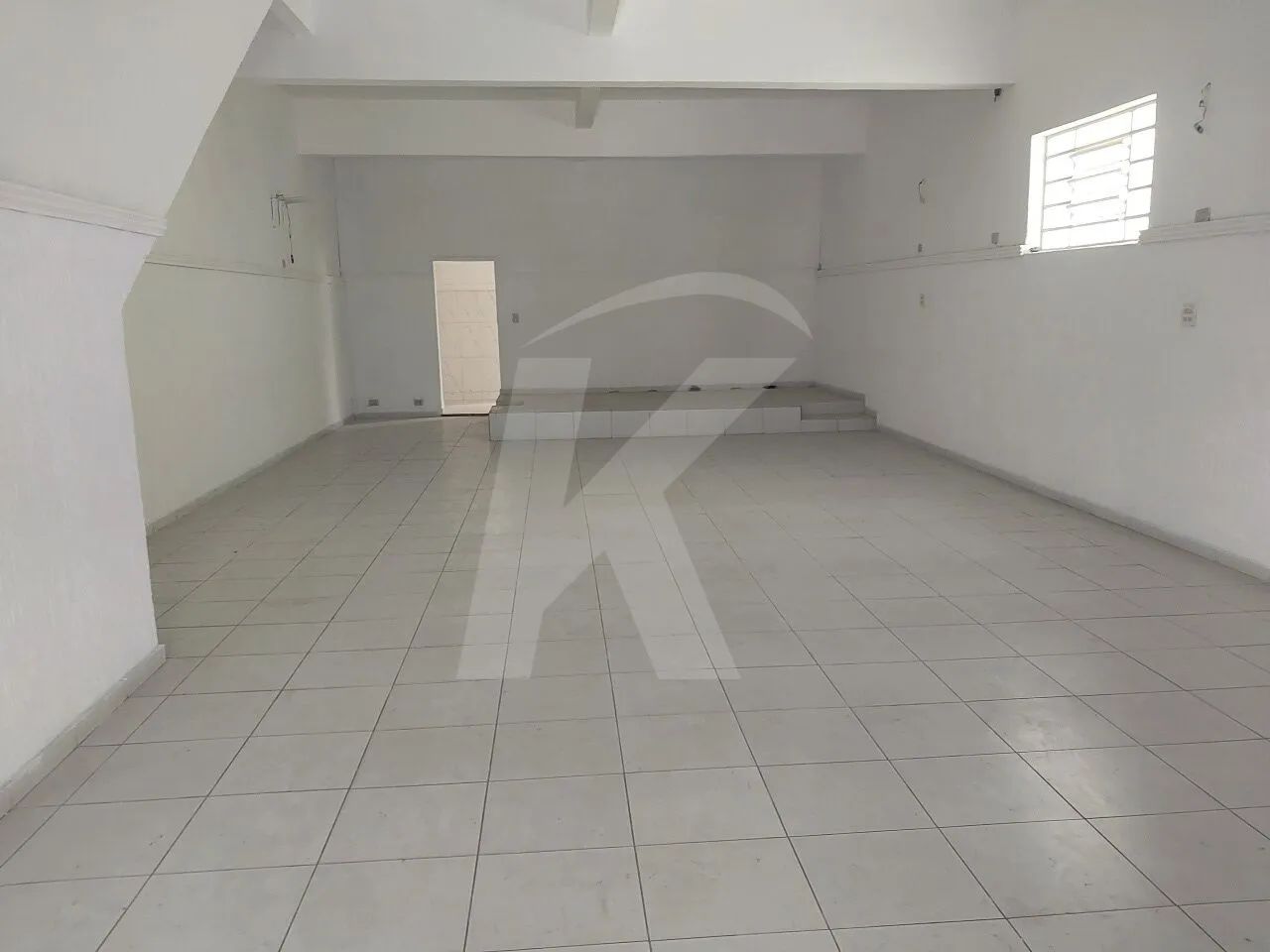 Salão comercial medindo 140 m² com 2 banheiros e 2 portas de aço.