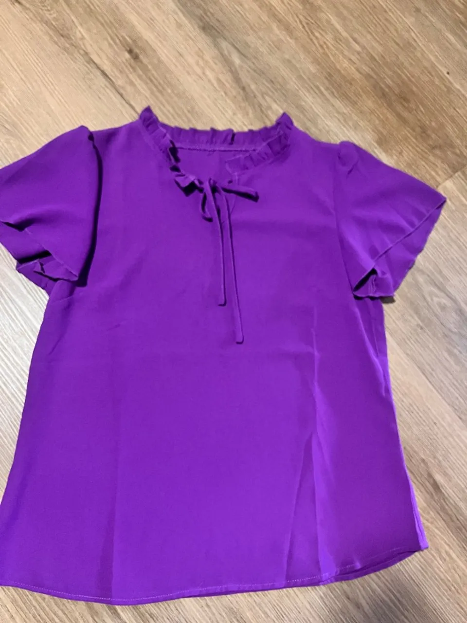 Blusa de manga com detalhe na gola roxa
