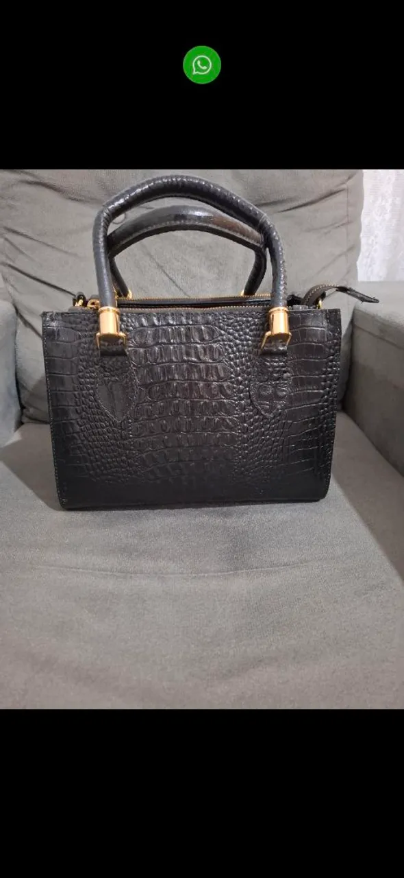 Bolsa preta com textura de crocodilo