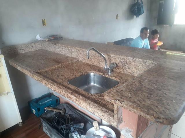 Vendo uma bancada e um balcão com a torneira e tudo