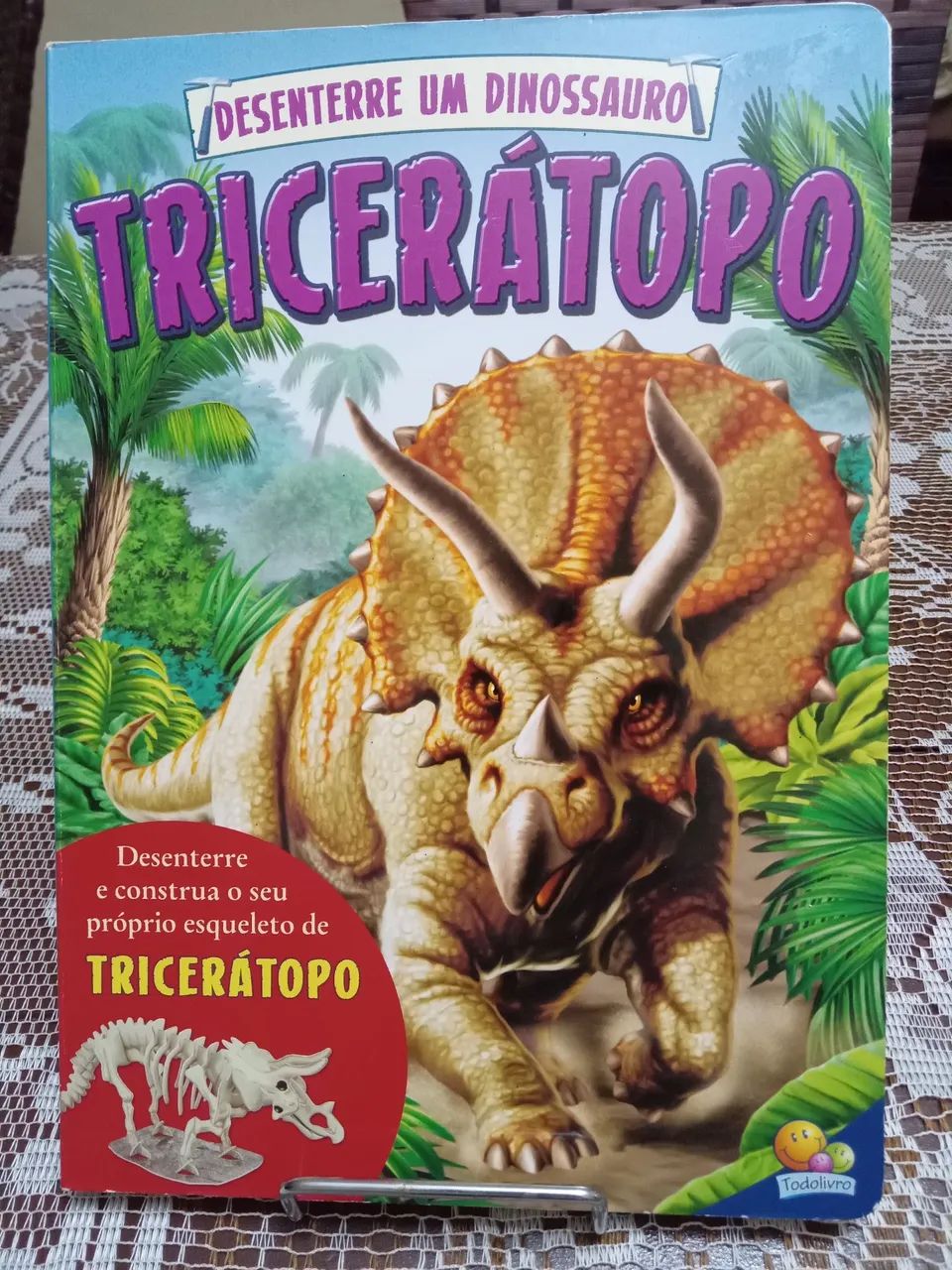 Livro "Desenterre um dinossauro" com partes para montar um dinossauro 
