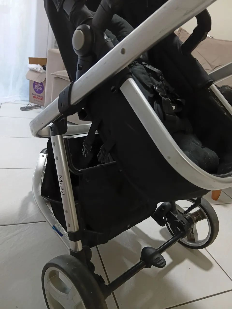  Carrinho de bebê com bebê conforto. 