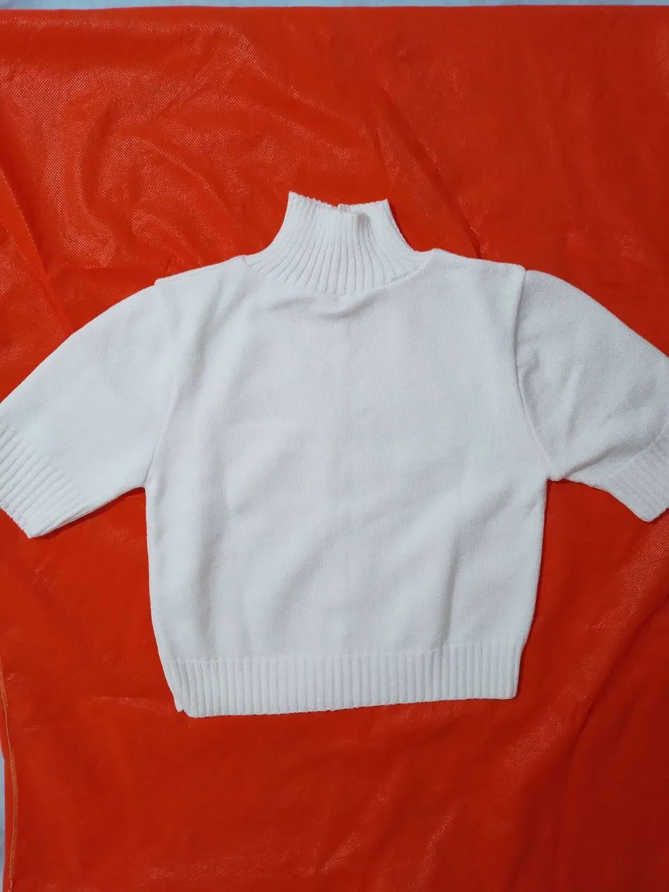 Blusa cropped de tricot off-withe com gola alta e mangas curtas. 