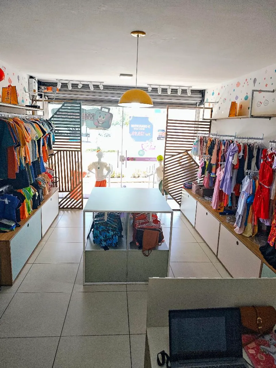 Loja de roupas infantis com manequins e expositores