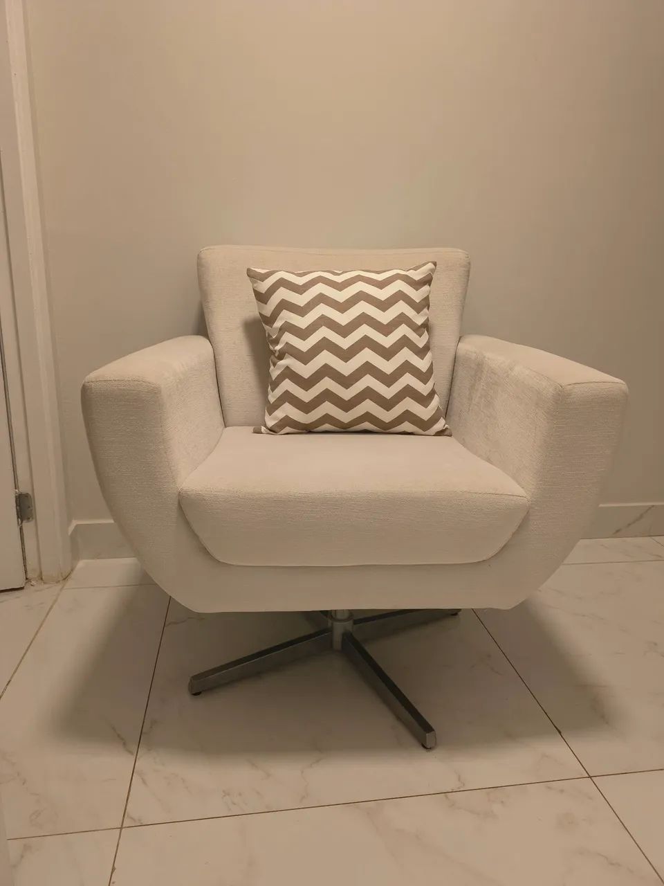 Beige armchair with stainless steel base, comfortable and suitable for various environments.