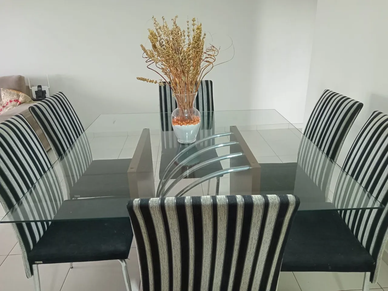 Mesa de jantar de vidro com cadeiras estofadas