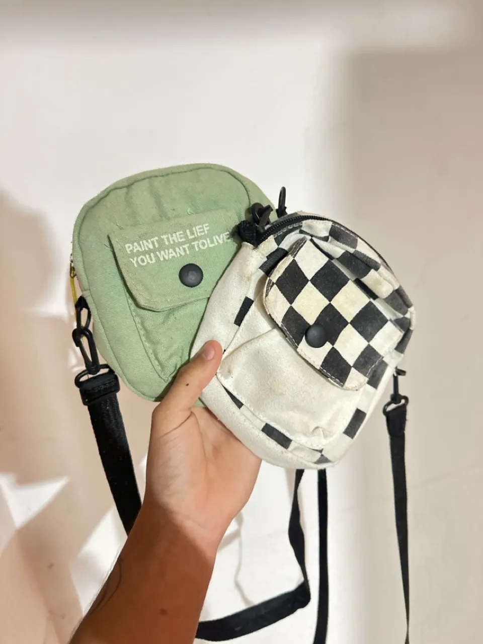Duas bolsas de ombro, verde e xadrez, usadas
