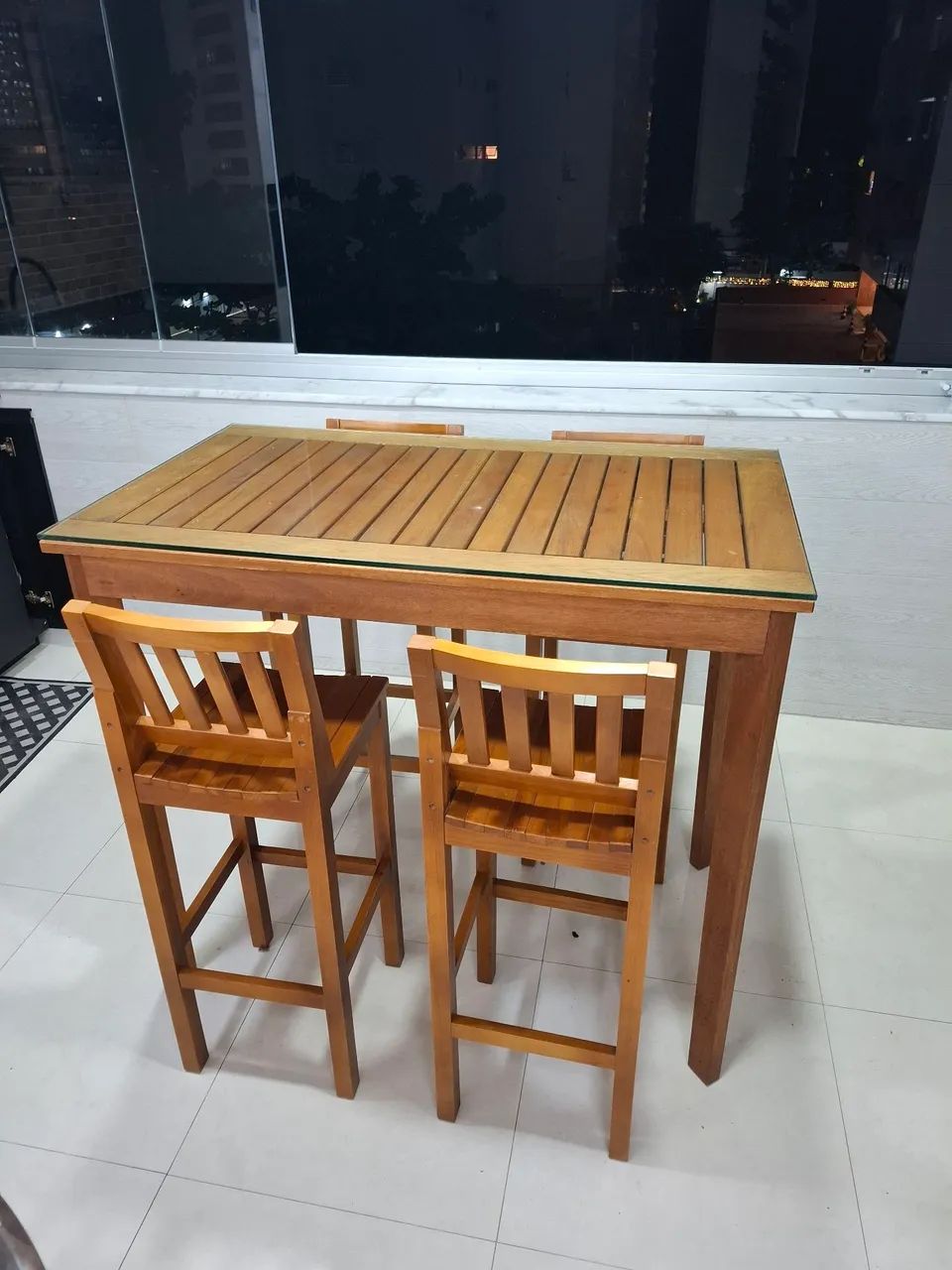Mesa alta de bar com cadeiras e tampo de vidro