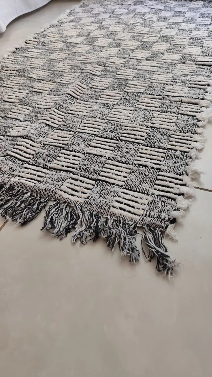 Tapete geométrico preto e branco com franjas