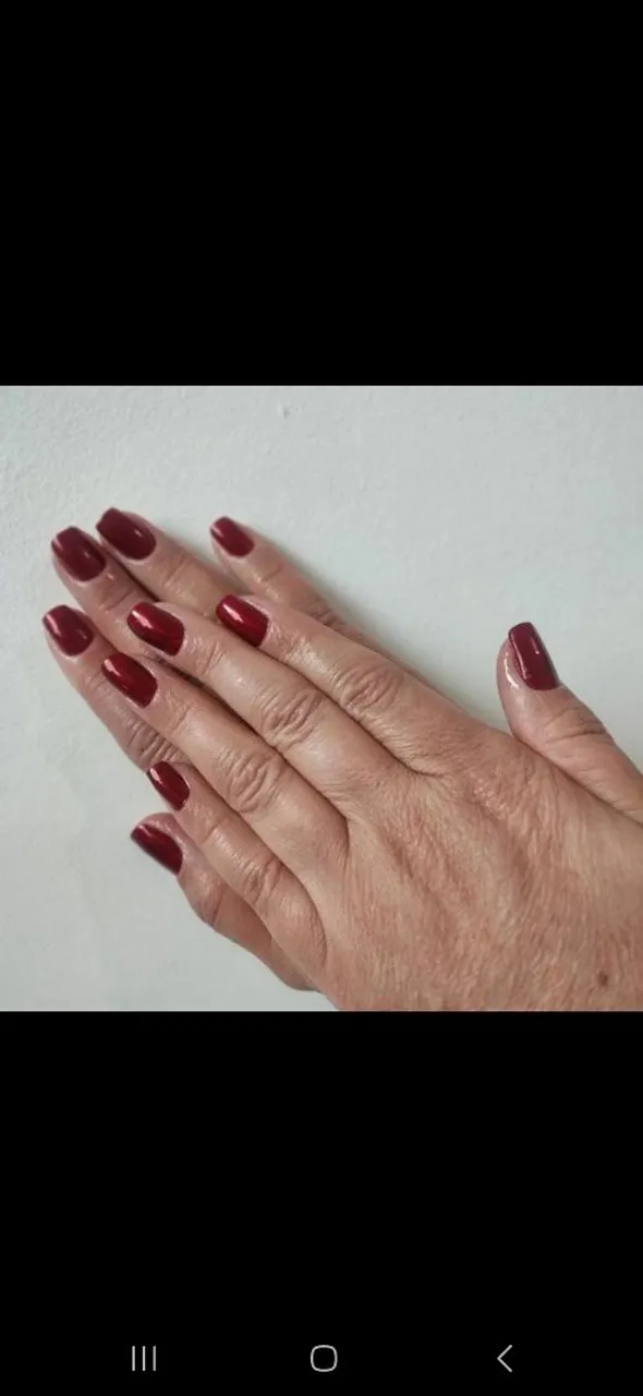 Unhas com esmaltação em tom vermelho