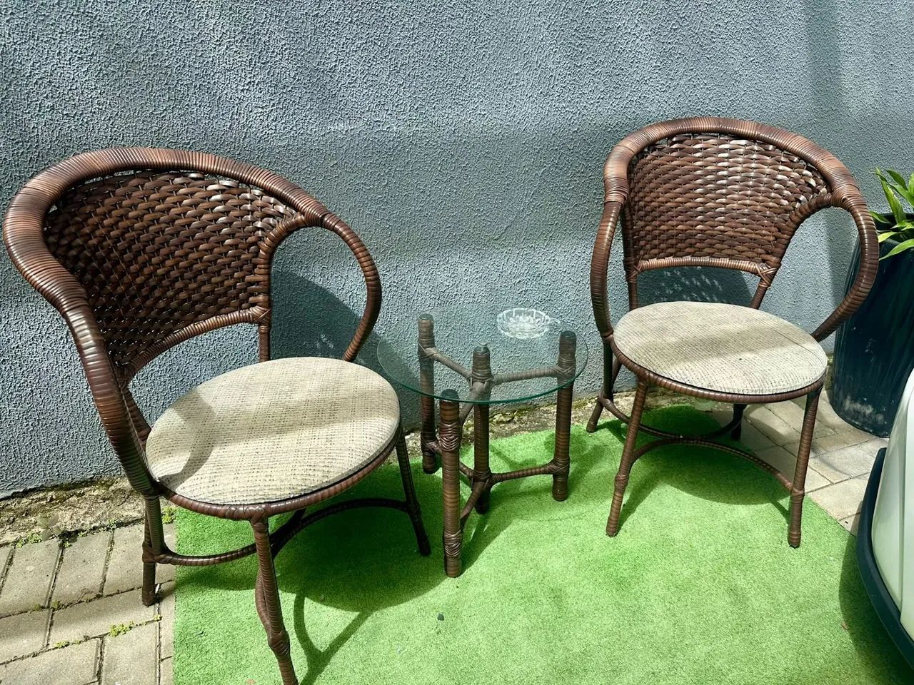 Jogo de duas cadeiras e mesa de vidro.