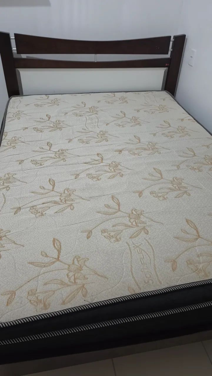 Cama de madeira com colchão de mola ensacada.
