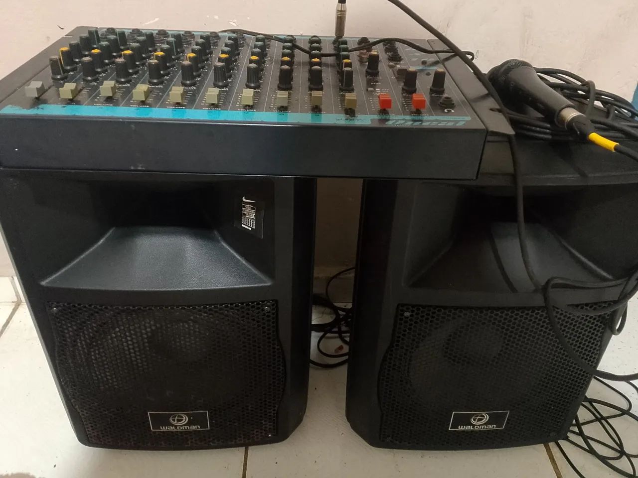 Caixa de som amplificada com mesa de 12 canais e um microfone 