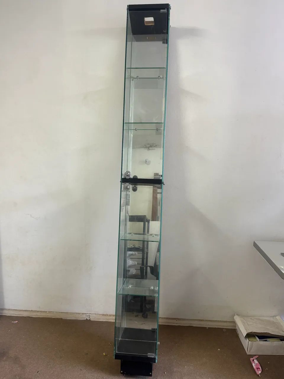 vitrine expositora de vidro, com prateleiras de vidro e porta com fechadura.