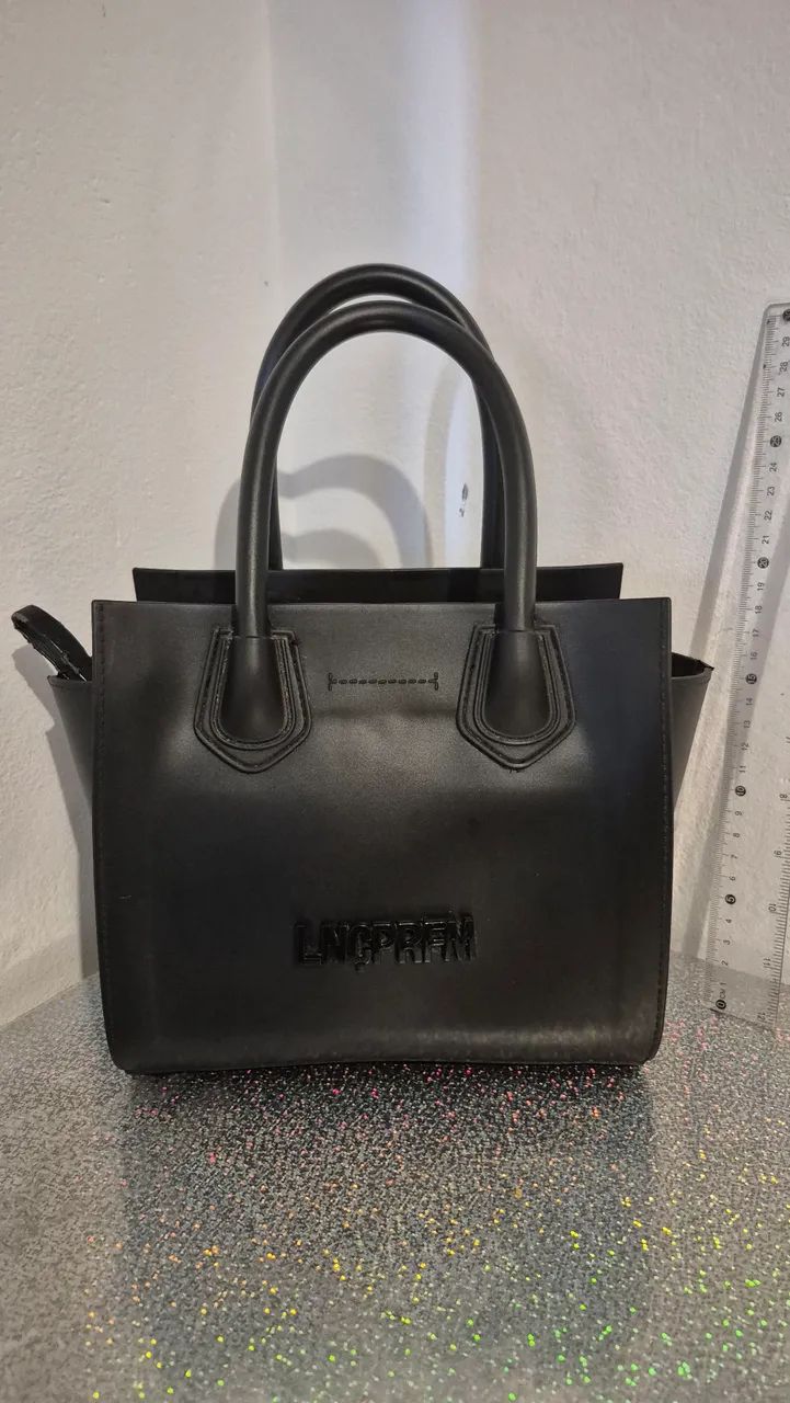 Bolsa preta lança perfume 