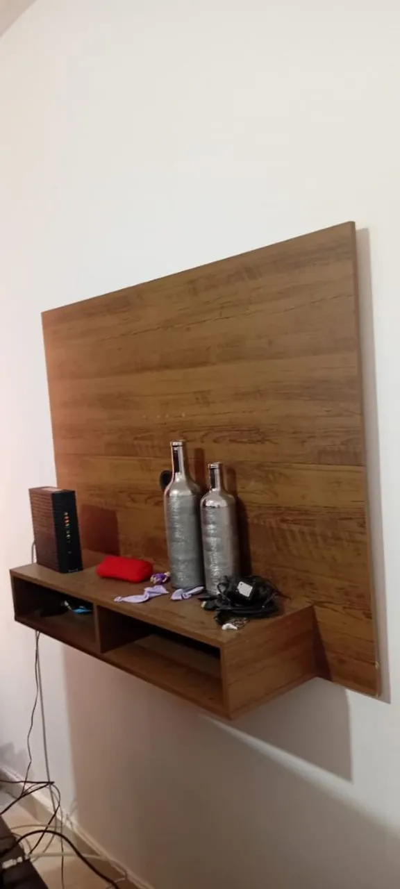 Painel de TV com prateleira e decoração