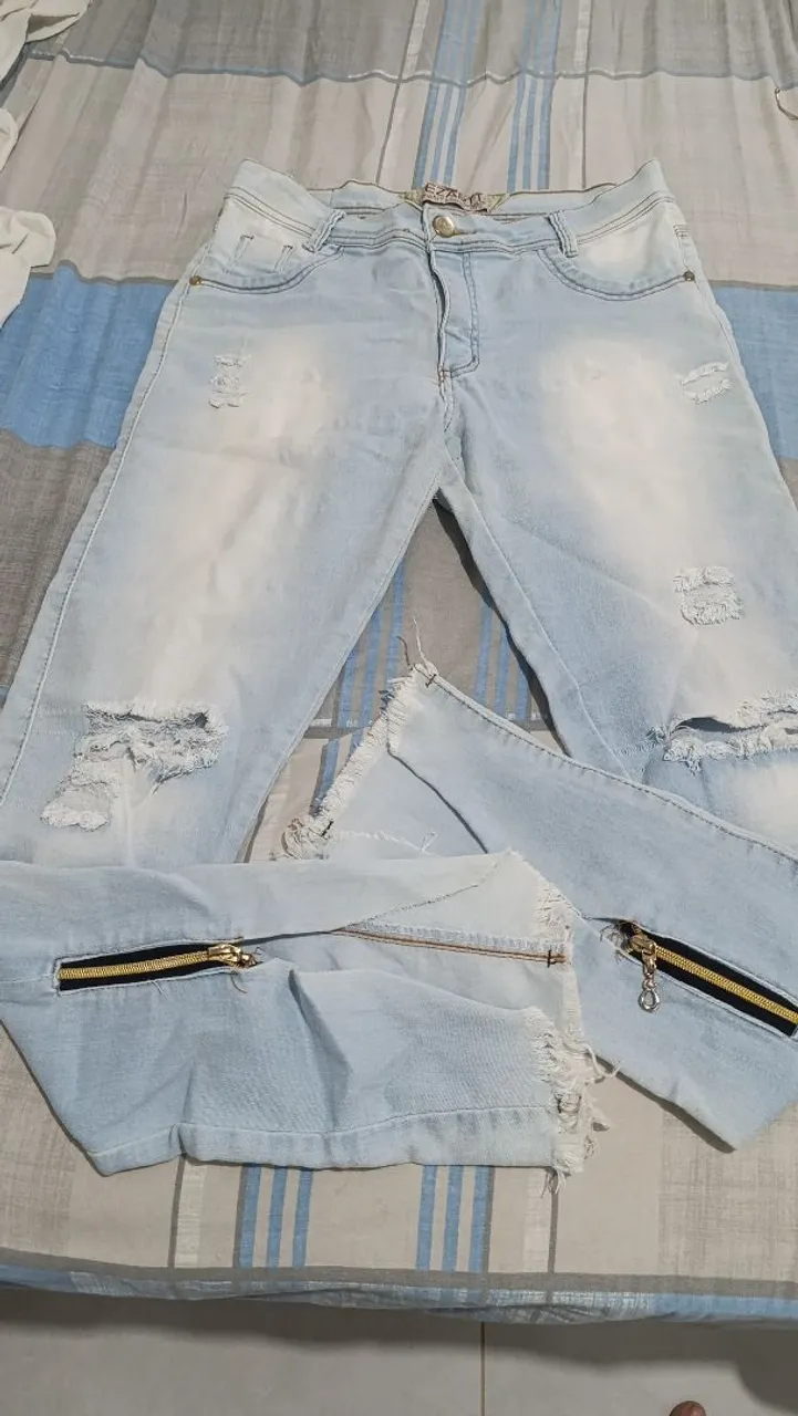 Calça jeans clara destroyed com zíper na barra