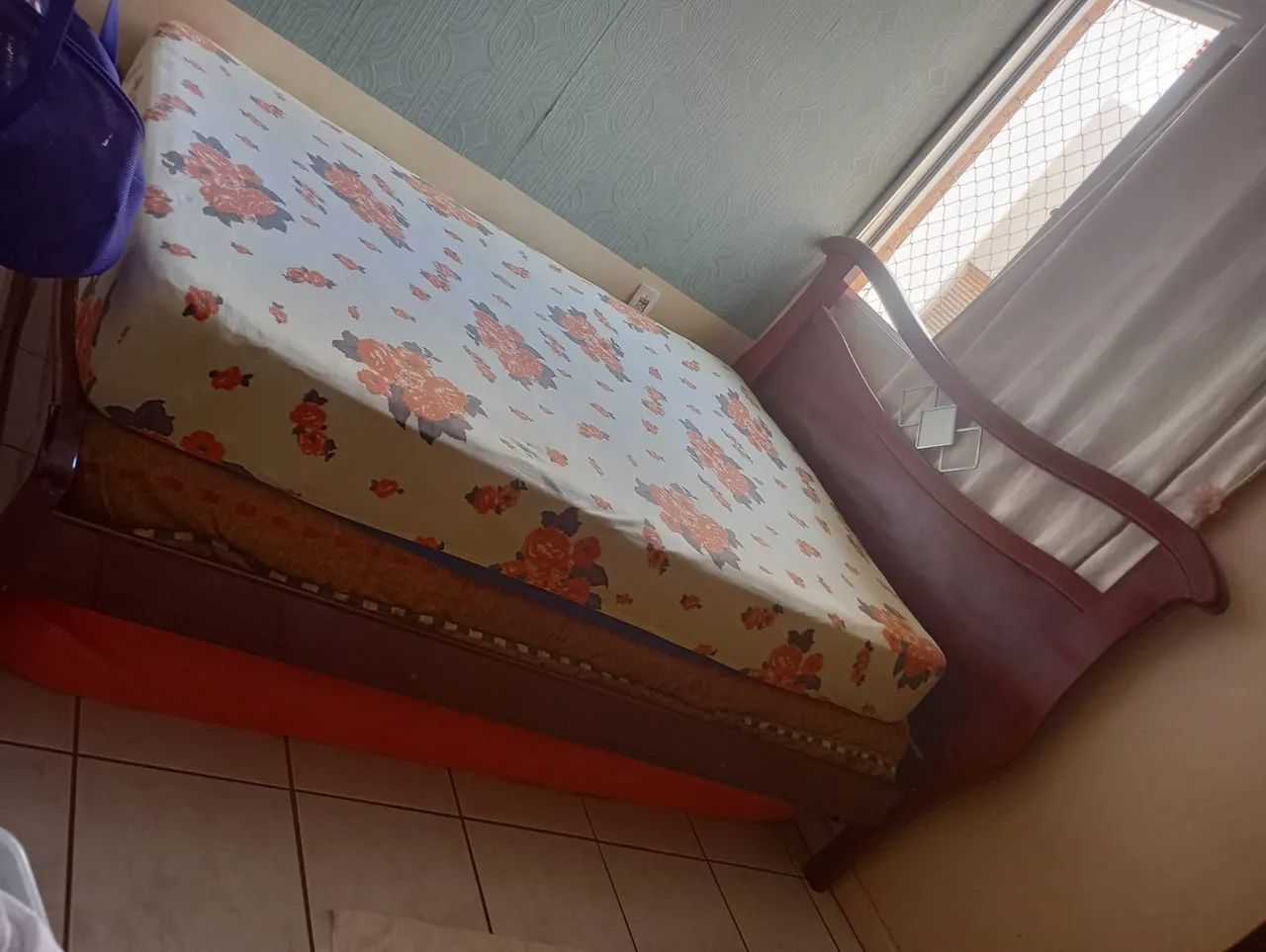 Cama de casal em madeira com colchão.
