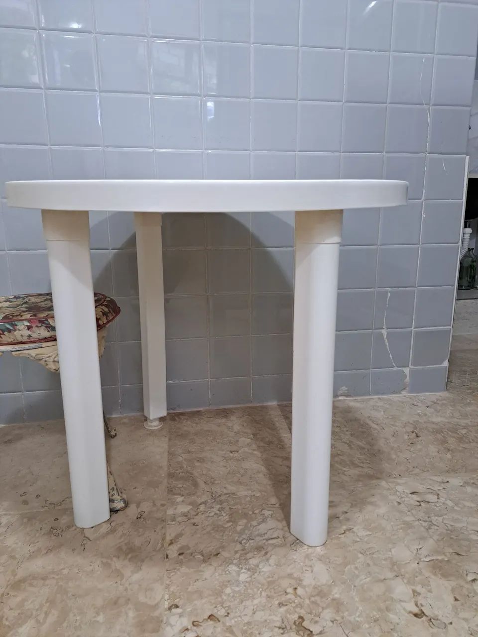 Mesa redonda e duas cadeiras brancas de plástico 
