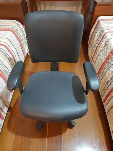 Poltrona preta com braços, forrada, com rodinhas e controle regulável