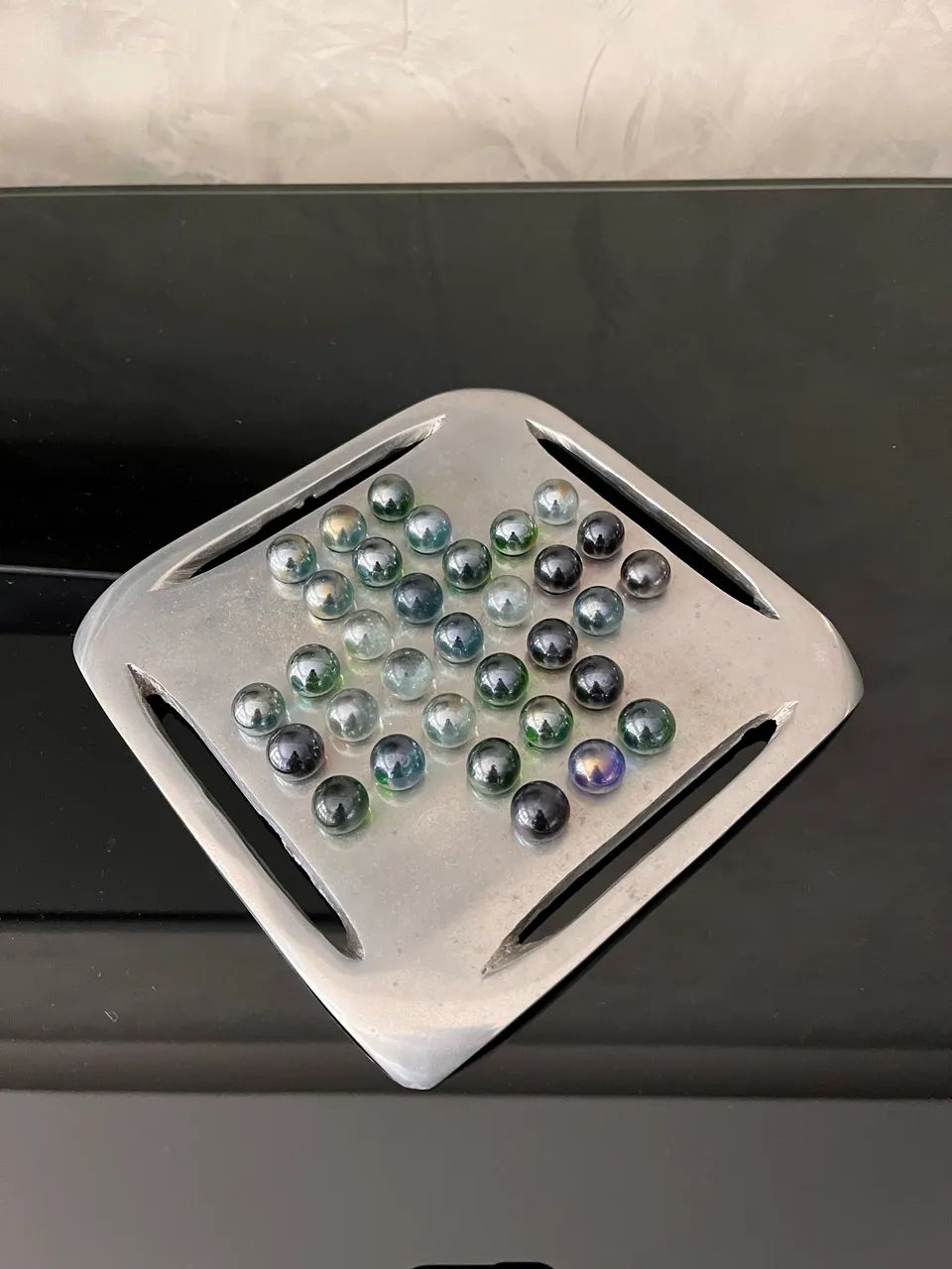 Jogo resta um em alumínio fundido e com bolinhas de gude. 