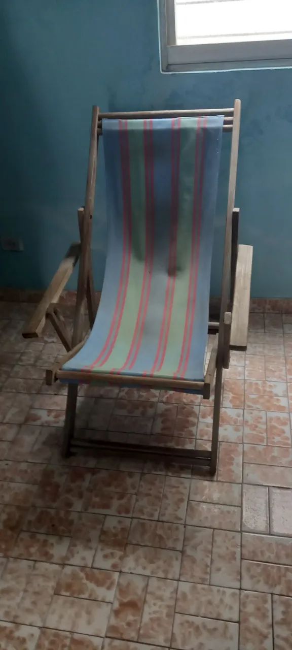 Espreguiçadeira em madeira com apoo para braços.