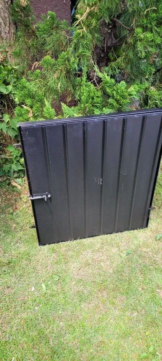 Porta de ferro com pintura de fundo preta, medindo 60 x 70 cm. 
