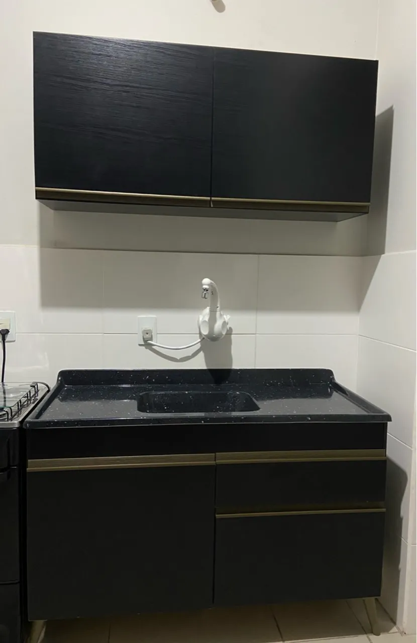 Armário de cozinha preto com detalhes dourados