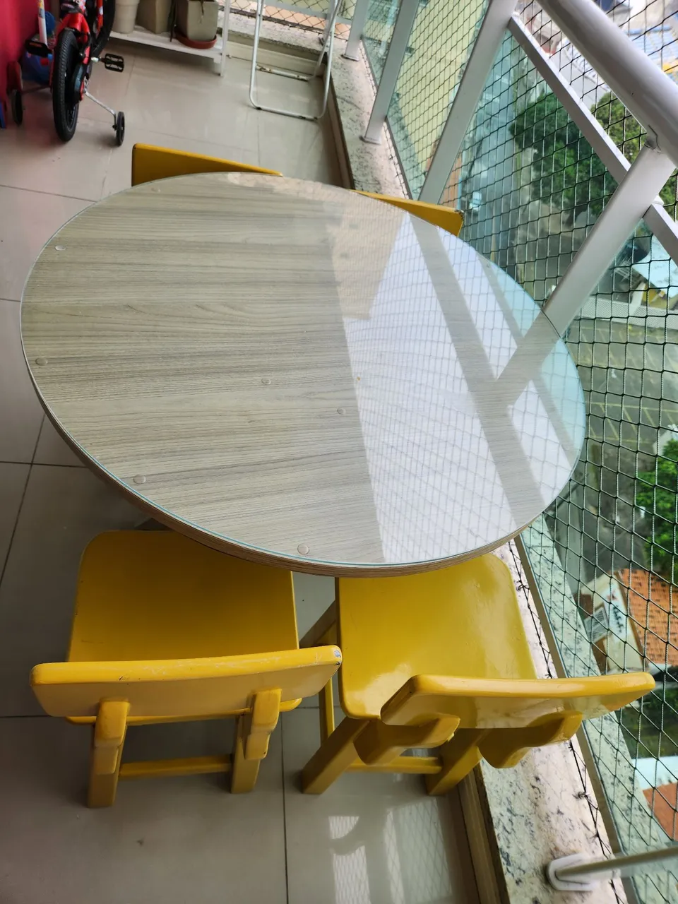 Mesa de varanda redonda em MDF com 4 cadeiras amarelas em madeira maciça