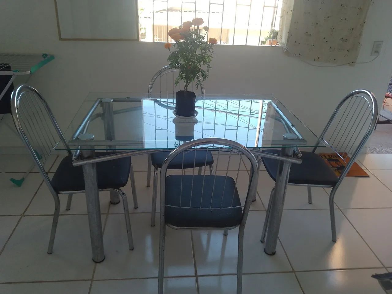 Mesa de vidro com 4 cadeiras.