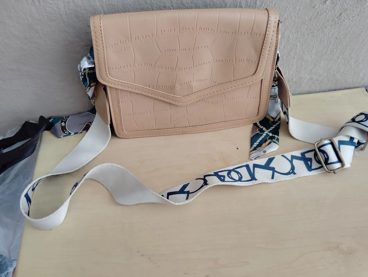 Bolsa de ombro bege com alça estampada